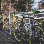 Rowery przypięte do barierki, na kierownicy kask rowerowy