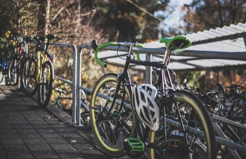 Rowery przypięte do barierki, na kierownicy kask rowerowy